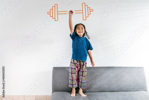 Konstfotografi A strong Asian little toddler kid girl lifting drawing weight against the white background