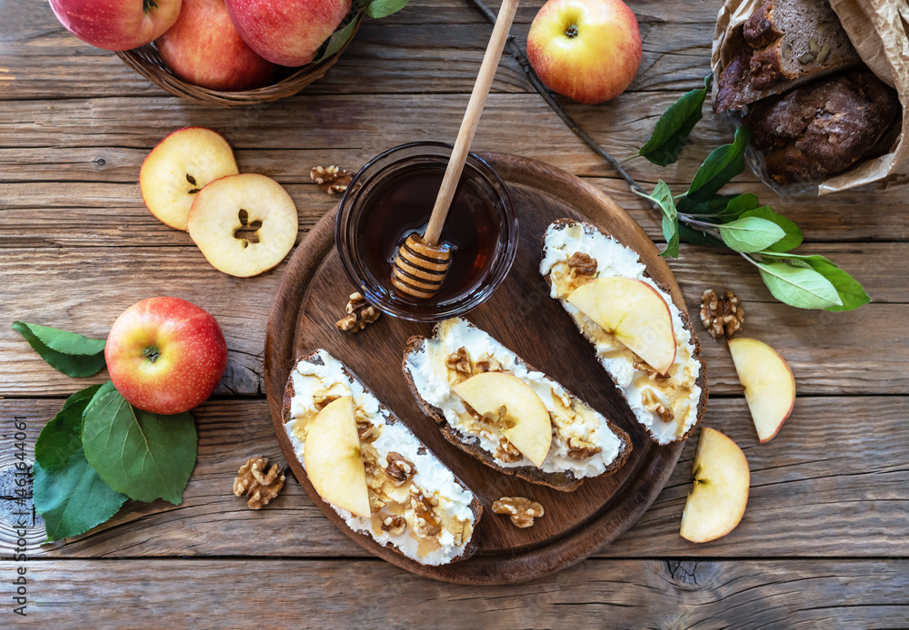 Bread slices with cottage cheese, honey, apples and nuts in rustic style