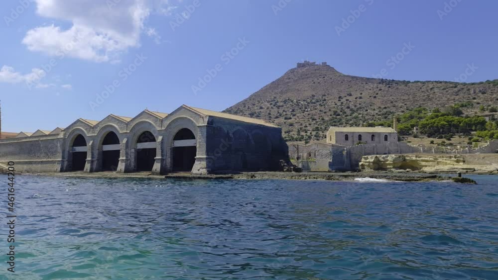 Florio tuna factory or tonnara at Favignana island from boat with Santa Caterina mount and castle in background, Italy. Slow-motion