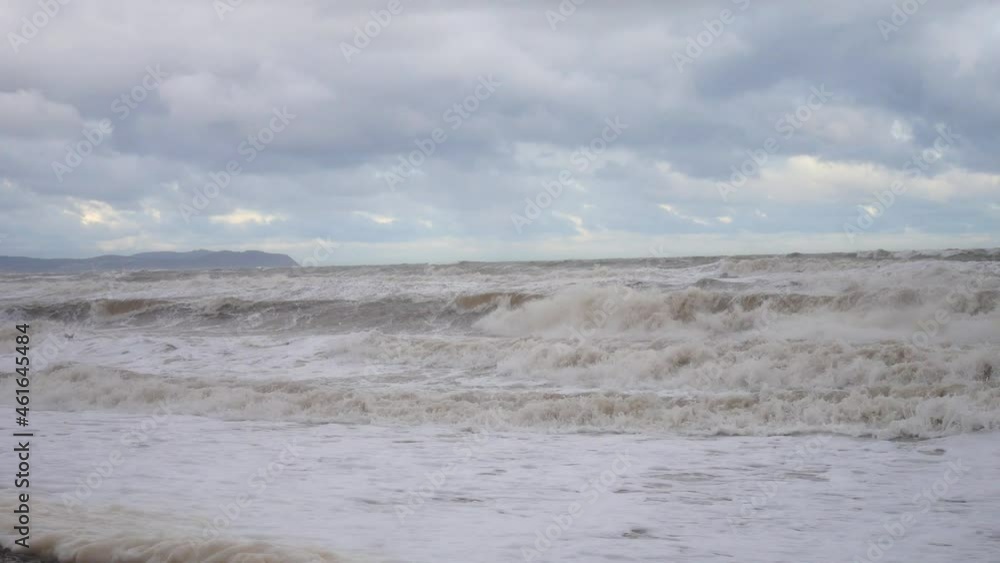 Powerful storm Sam rolling coastal ocean waves foam blowing in rough windy weather conditions Powerful storm Sam rolling coastal ocean waves foam blowing in rough windy weather conditions