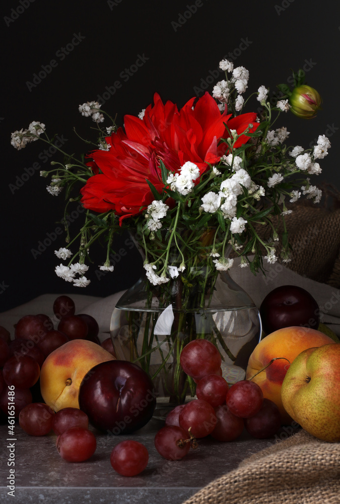 Still life with a red flower and fruit on a dark background Still life with a red flower and fruit on a dark background