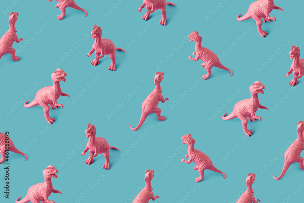 Fototapeta premium Creative isometric pink painted dinosaur toy pattern on blue background. Minimal abstract concept for school and kids.