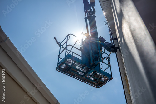 Worker on a aerial access platform, cherry picker, cleaning house