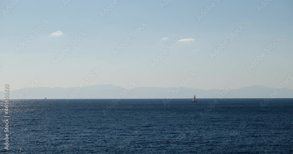 Traveling sailing boat in far distance on water surface. Natural sunlight shimmering and reflecting over sea background with large copy space in 4k resolution. Amazing aqua view. Summer vacation. Traveling sailing boat in far distance on water surface. Natural sunlight shimmering and reflecting over sea background with large copy space in 4k resolution. Amazing aqua view. Summer vacation.