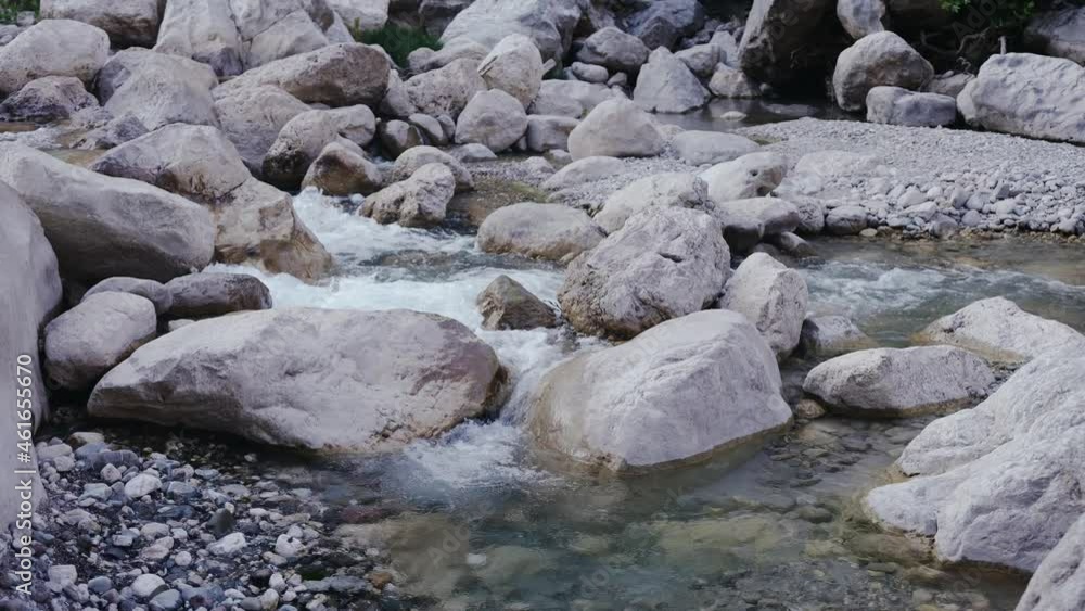 Slow stream of a mountain river. All around are white stones and rocks. Picturesque landscape. Travel, adventure. High quality 4k footage Slow stream of a mountain river. All around are white stones and rocks. Picturesque landscape. Travel, adventure. High quality 4k footage
