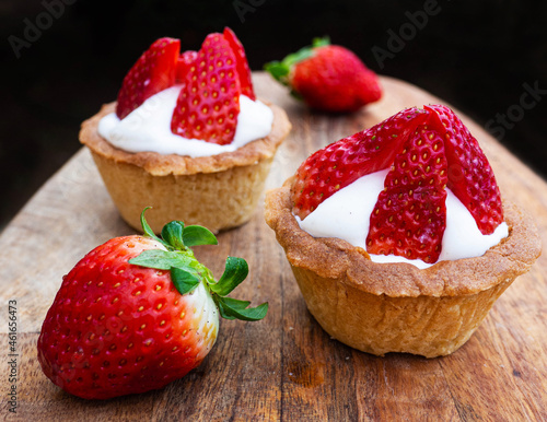 Freshly baked baskets with curd cream and strawberries