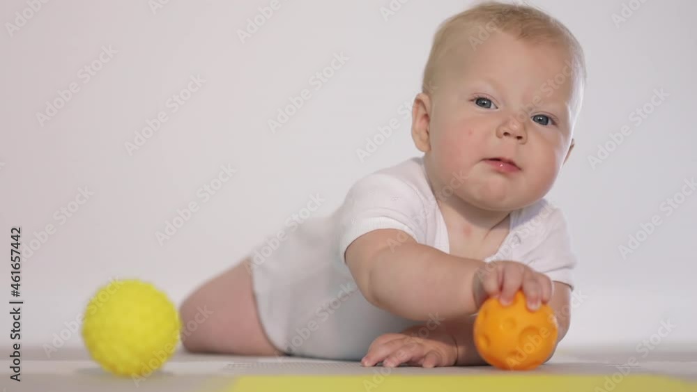 Adorable blonde infant plays with toy, home indoor Adorable blonde infant plays with toy, home indoor