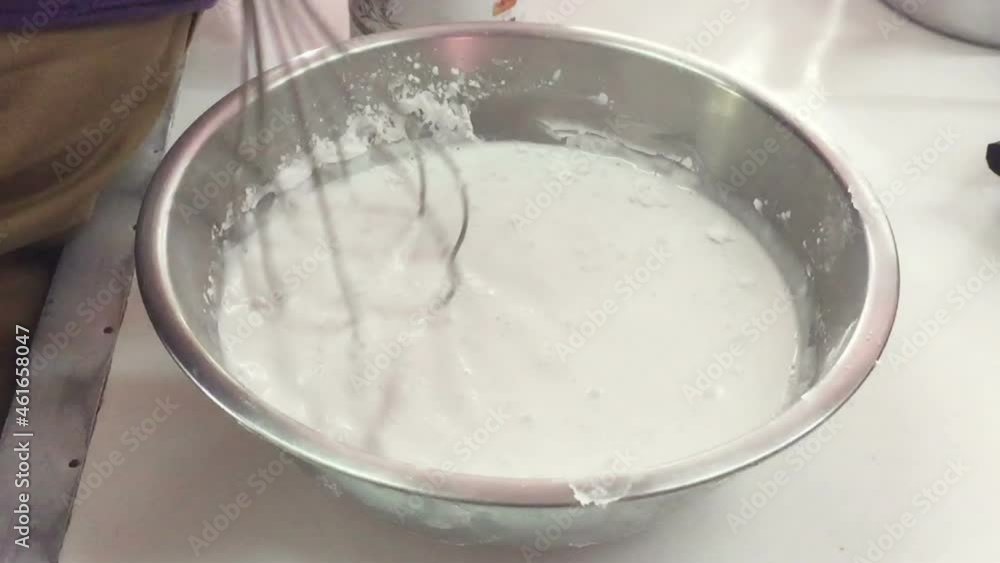 close up whisking butter , eggs and cream in bowl close up whisking butter , eggs and cream in bowl