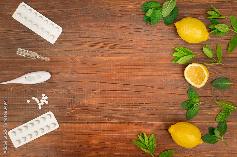 Medicine vs natural alternative remedies background. Pills, tablets, thermometer, medicine vs lemons and mint on brown wooden background. Natural medicine vs conventional medicine concept. Copy space Medicine vs natural alternative remedies background. Pills, tablets, thermometer, medicine vs lemons and mint on brown wooden background. Natural medicine vs conventional medicine concept. Copy space