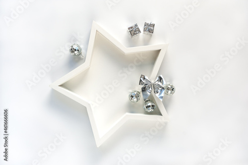 Star shape plate with gifts and silver bow on white background. Abstract background for greeting card, poster. Soft focus, copy space.