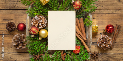 Christmas Composition with a blank card, fir branches and decorations on wooden table
