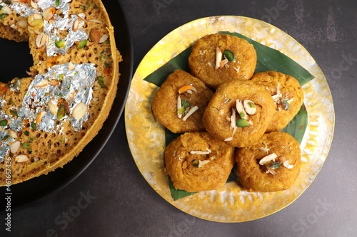 Indian traditional sweet balushahi served on a metal plate over black background. Also known as Balsaahi, badushah is a sweet food served on a Brass plate over moody background. Copy space. photo