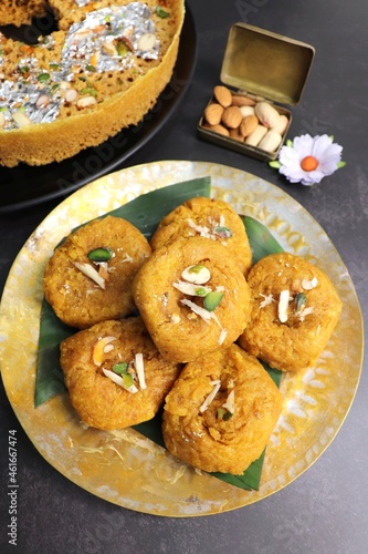 Indian traditional sweet balushahi served on a metal plate over black background. Also known as Balsaahi, badushah is a sweet food served on a Brass plate over moody background. Copy space.