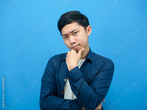 Man gesture serious thinking about something blue background