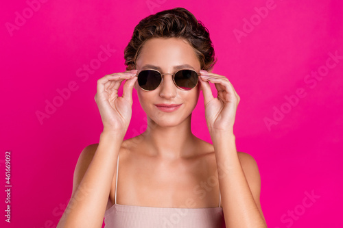 Photo of positive cool cheerful young lady wear sunglass charming face isolated on magenta color background © deagreez