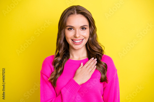 Photo of charming attentive curly young lady dressed pink pullover arm chest listening anthem isolated yellow color background