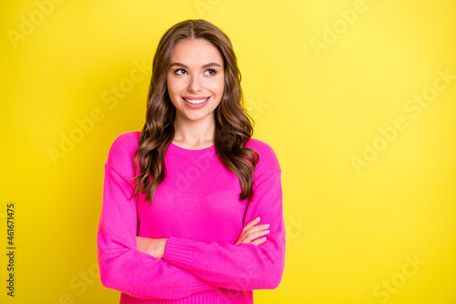 Photo of young attractive girl happy positive smile crossed hands look empty space isolated over yellow color background