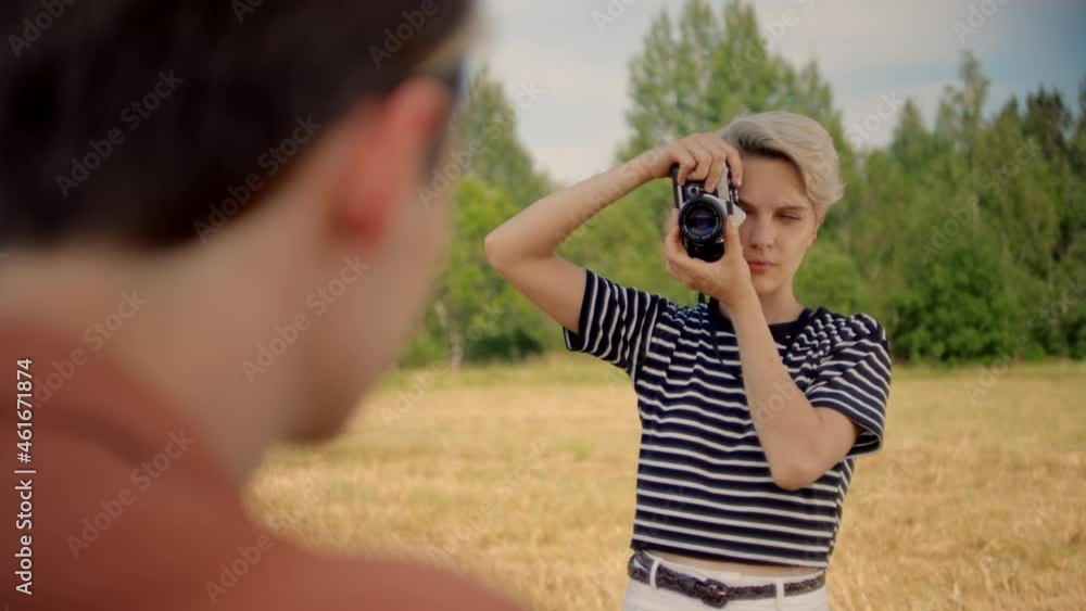 Young professional female photographer on commercial photoshoot outdoors, directs and gives instructions to male model in front. Confident and empowered women in profession. Photography skill Young professional female photographer on commercial photoshoot outdoors, directs and gives instructions to male model in front. Confident and empowered women in profession. Photography skill
