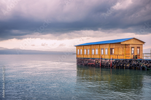 A pier and a wooden house with a restaurant on the shore of Lake Sevan in Armenia. © EdNurg