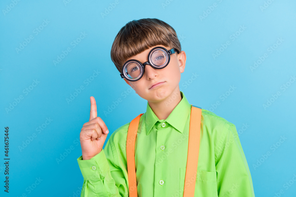 Portrait of attractive brainy schoolboy nerd pointing up solution isolated over teal turquoise color background Portrait of attractive brainy schoolboy nerd pointing up solution isolated over teal turquoise color background