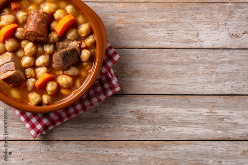 Traditional Spanish cocido madrileño in bowl on rustic wooden table.Copy space