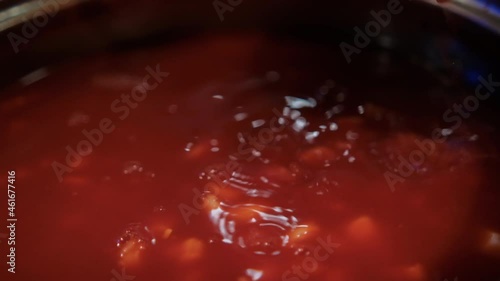 Ladle stirring delicious traditional Mexican pozole in cooking pot