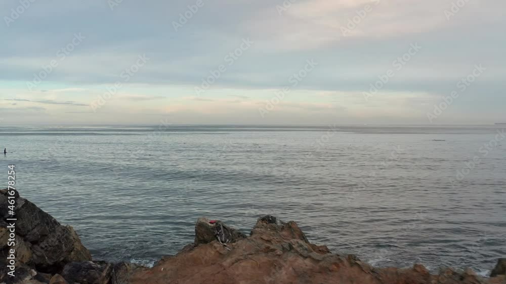 Flyover of a woman on the beach and then towards the endless ocean horizon at sunset Flyover of a woman on the beach and then towards the endless ocean horizon at sunset