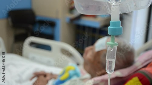 close up IV Drip , an elderly male patient in bed in a hospital