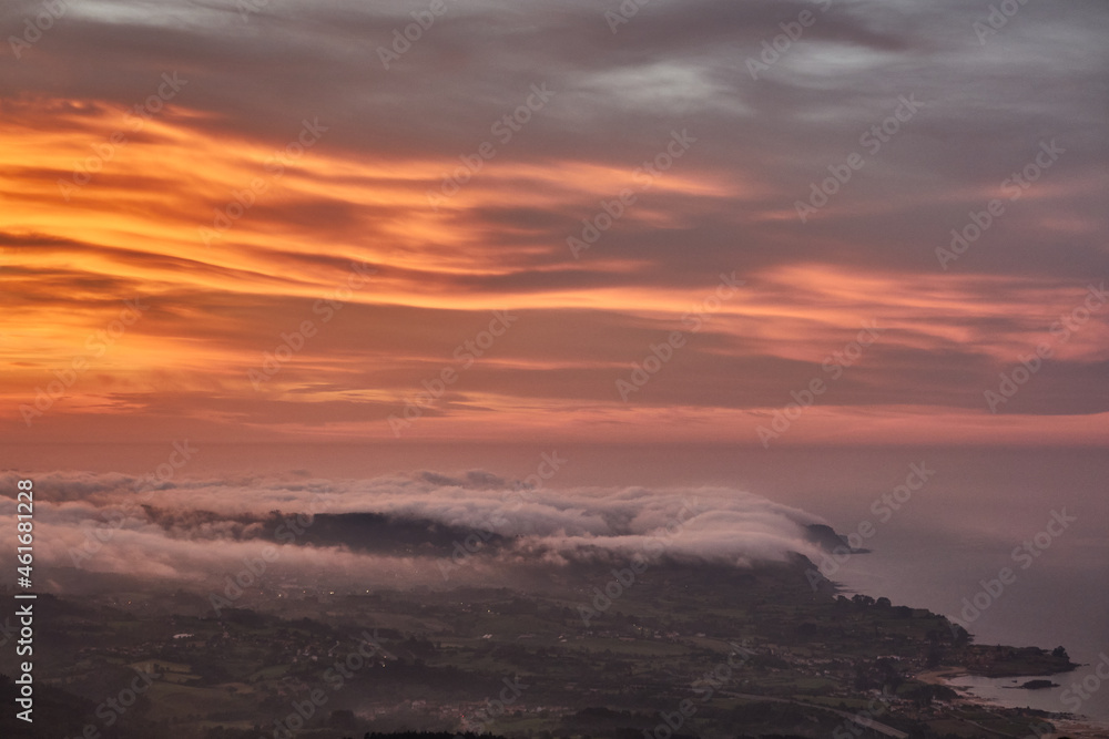 Clouds descend over Playa de la Isla at sunset. Asturias. Spain