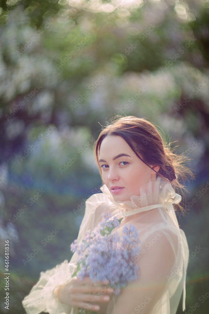 Portrait of young woman in garden among blooming lilac shrubs. Portrait of young woman in garden among blooming lilac shrubs.