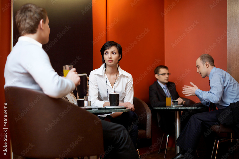 Business people talking at tables in coffee shop