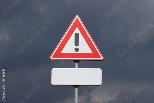 A sign with a exclamation mark warning for a dangerous situation ahead and a smaller sign below with space for an editor to place own text
