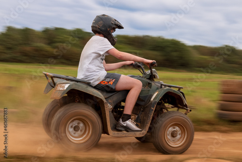 A young boy quad biking on the dusty hills of South Wales