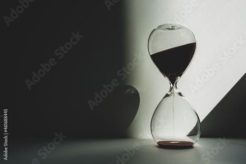 Time is measured by an hourglass in the twilight illuminated by sunlight. photo