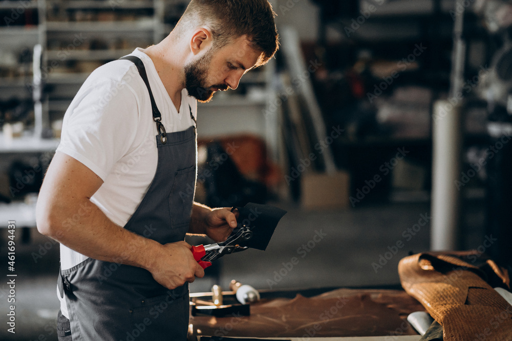Man tailor working with leather fabric Man tailor working with leather fabric