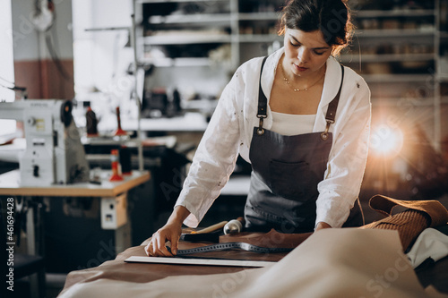 Tableau sur toile Woman tailor working on leather fabric
