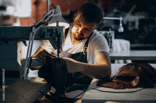 Man tailor working with leather fabric