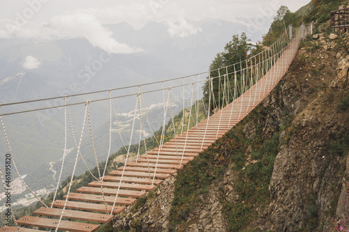 Beautiful suspension bridge in the mountains. An exciting force of nature. Human buildings among the wild. Beautiful photo of nature for the background