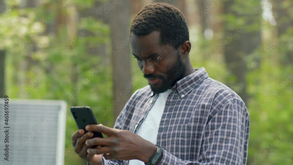 Horizontal slow motion shot young African American man taking pictures of local forest on smartphone camera Horizontal slow motion shot young African American man taking pictures of local forest on smartphone camera