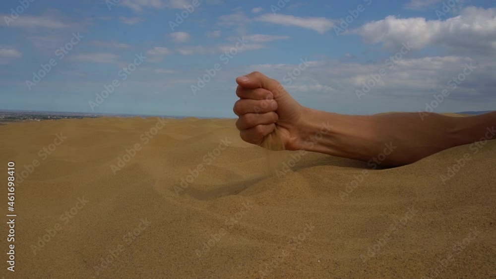 Close-up hand releasing dropping sand. Sand flowing through the hands. Close-up hand releasing dropping sand. Sand flowing through the hands.