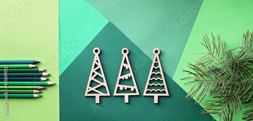 Tree simple wooden trees and many various shade of green color pencils lay on the green color gradation paper background, branches of different fir trees, original craft and diy concept for kid photo