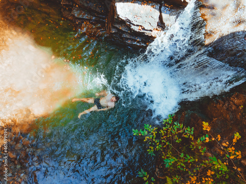 overhead view of man swimming in autumn waterfall