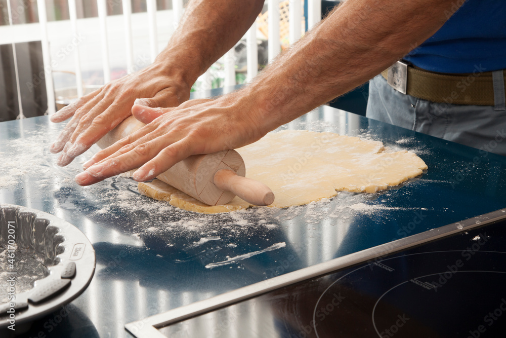 Manos de cocinero amasando masa con rodillo de cocina. Cook hands kneading dough with kitchen rolling pin. Manos de cocinero amasando masa con rodillo de cocina. Cook hands kneading dough with kitchen rolling pin.