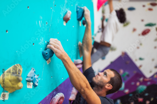 Handsome athletic men climbing on a indoor climbing wall. Extreme sports concept.