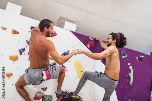 Handsome athletic men climbing on a indoor climbing wall. Extreme sports concept. © hedgehog94