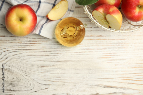 Natural apple vinegar and fresh fruits on white wooden table, flat lay. Space for text