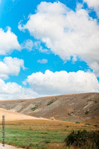 Beautiful landscape of mountainous terrain with hills against a blue sky with clouds