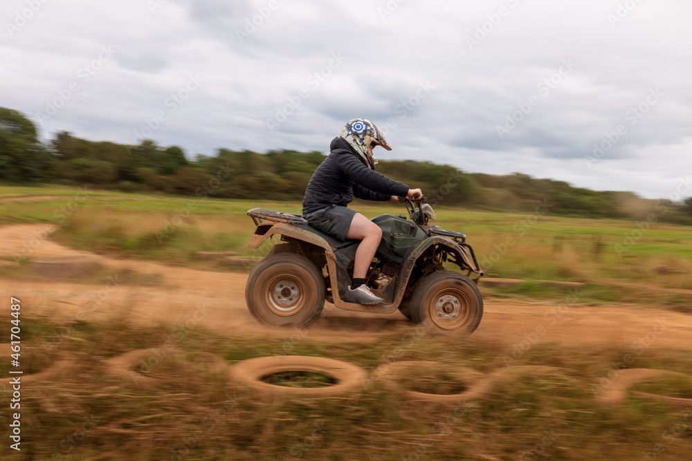 A young boy quad biking on the dusty hills of South Wales