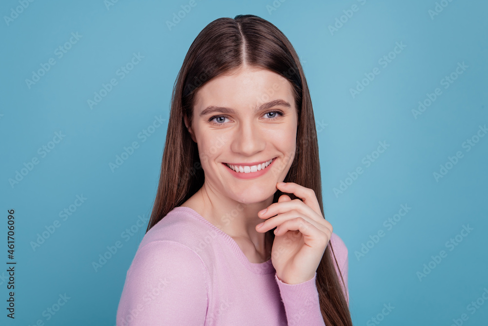 Close up photo of nice attractive girl happy positive toothy smile hand touch chin isolated over blue color background Close up photo of nice attractive girl happy positive toothy smile hand touch chin isolated over blue color background
