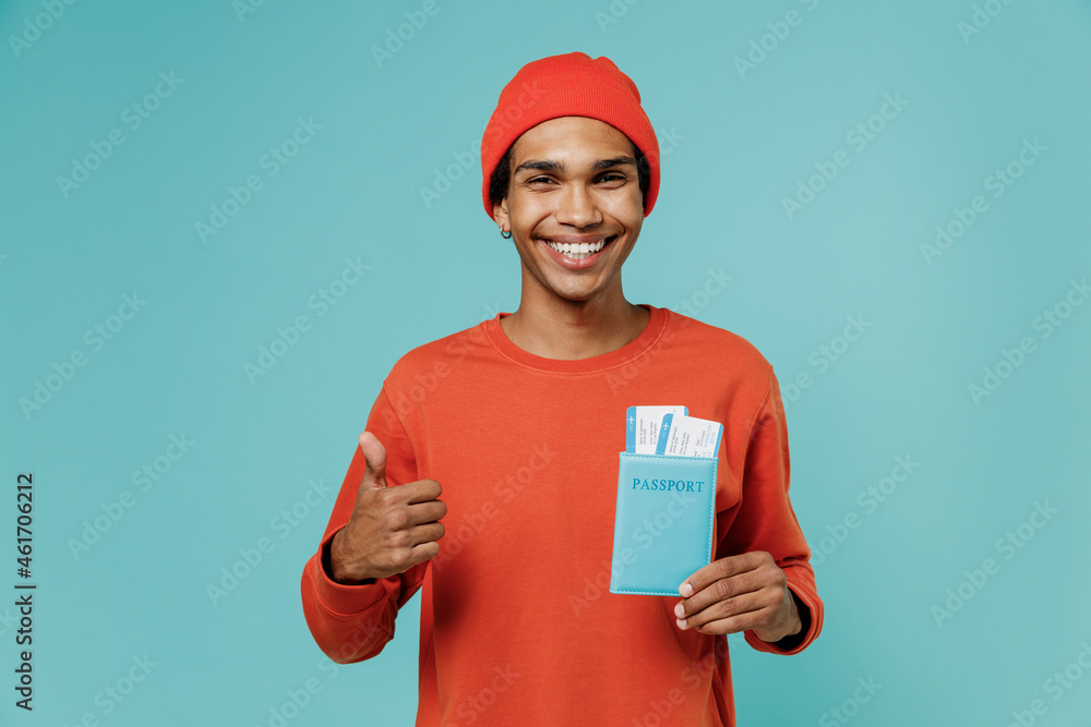 Traveler tourist african american man in red clothes hold passport tickets show thumb up isolated on pastel light blue background studio. Passenger travel abroad weekends getaway. Air flight concept. Traveler tourist african american man in red clothes hold passport tickets show thumb up isolated on pastel light blue background studio. Passenger travel abroad weekends getaway. Air flight concept.